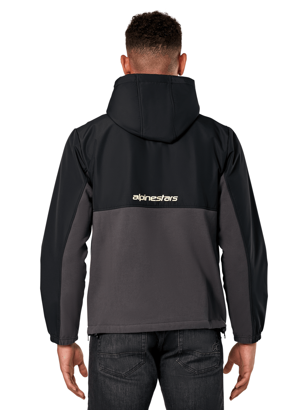 Chaqueta híbrida Alpinestars Juncture, vista posterior, negro y gunmetal, anorak deportivo casual de material mixto, parte superior de ripstop y parte inferior de forro polar de lona, logotipo de Alpinestars en la espalda, usado con pantalones oscuros