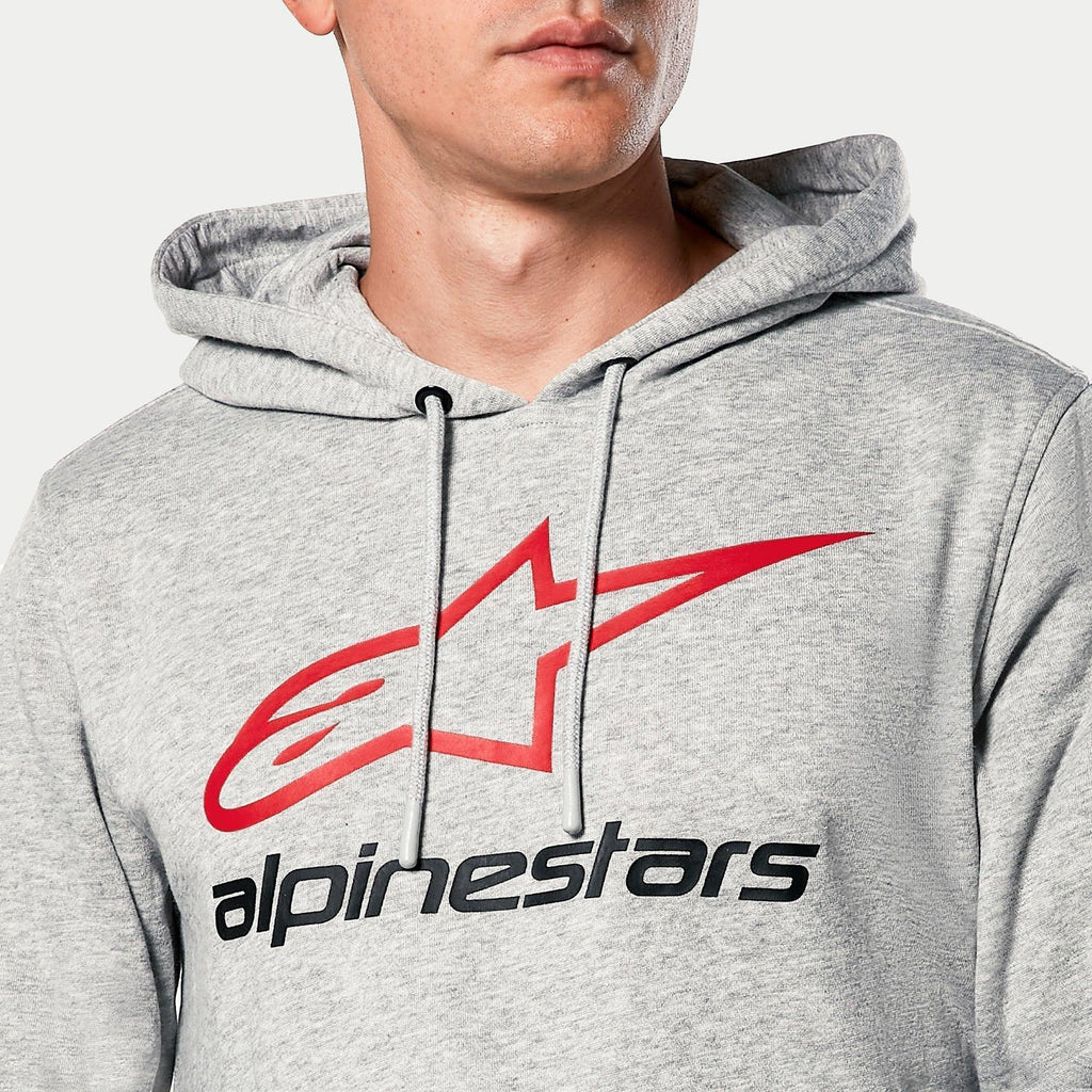 Sudadera con capucha Alpinestars Always V3, gris jaspeado, primer plano del pecho con logotipo de estrella roja y texto Alpinestars en negro, capucha con forro de jersey y cordones grises, ropa urbana casual de automovilismo