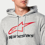Sudadera con capucha Alpinestars Always V3, gris jaspeado, primer plano del pecho con logotipo de estrella roja y texto Alpinestars en negro, capucha con forro de jersey y cordones grises, ropa urbana casual de automovilismo