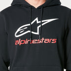 Alpinestars Always V3 Hoodie, sudadera negra tipo pullover, con el logotipo de la estrella blanca y el texto de Alpinestars en rojo en el pecho, cordones negros con puntas sumergidas, estilo streetwear casual inspirado en el automovilismo