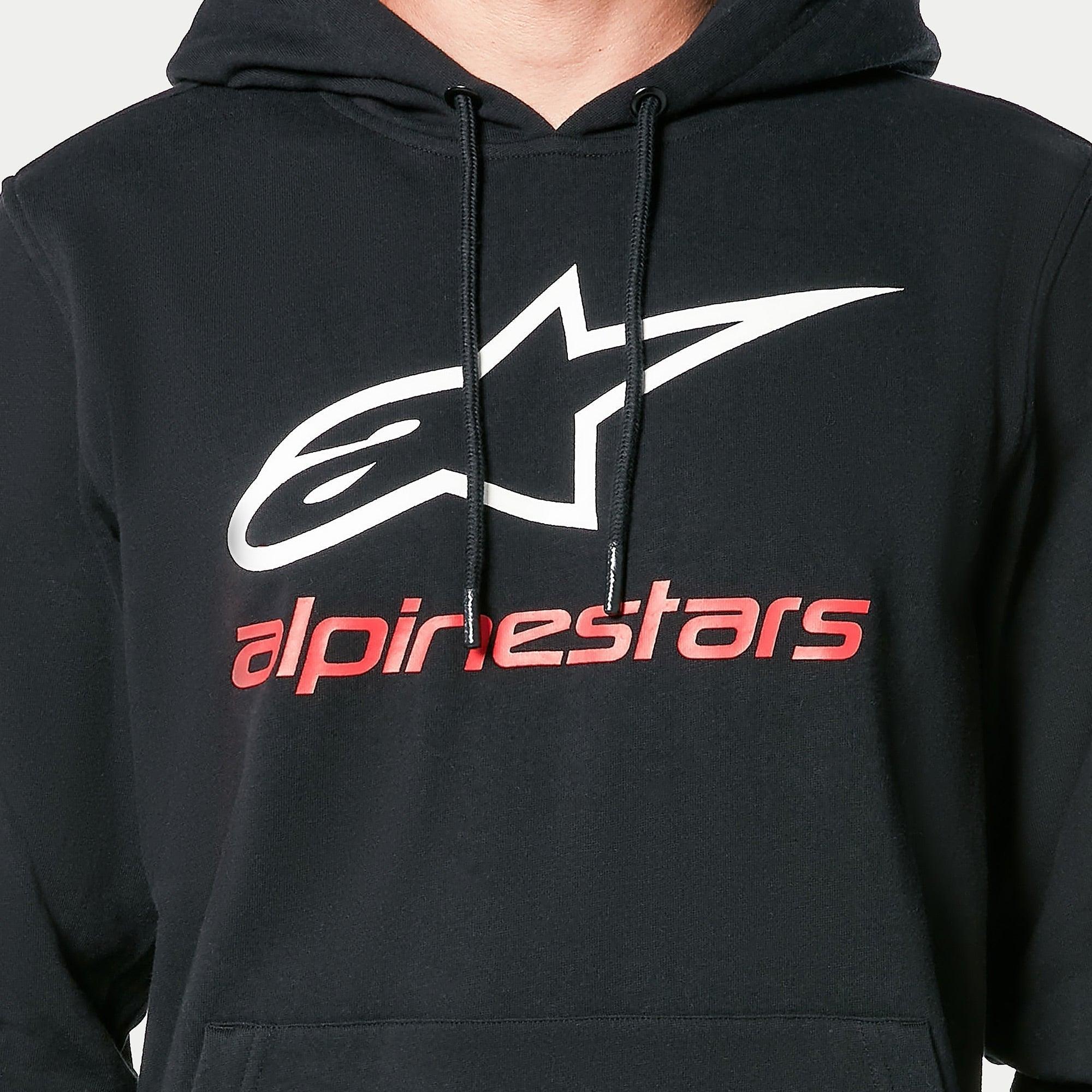 Alpinestars Always V3 Hoodie, sudadera negra tipo pullover, con el logotipo de la estrella blanca y el texto de Alpinestars en rojo en el pecho, cordones negros con puntas sumergidas, estilo streetwear casual inspirado en el automovilismo