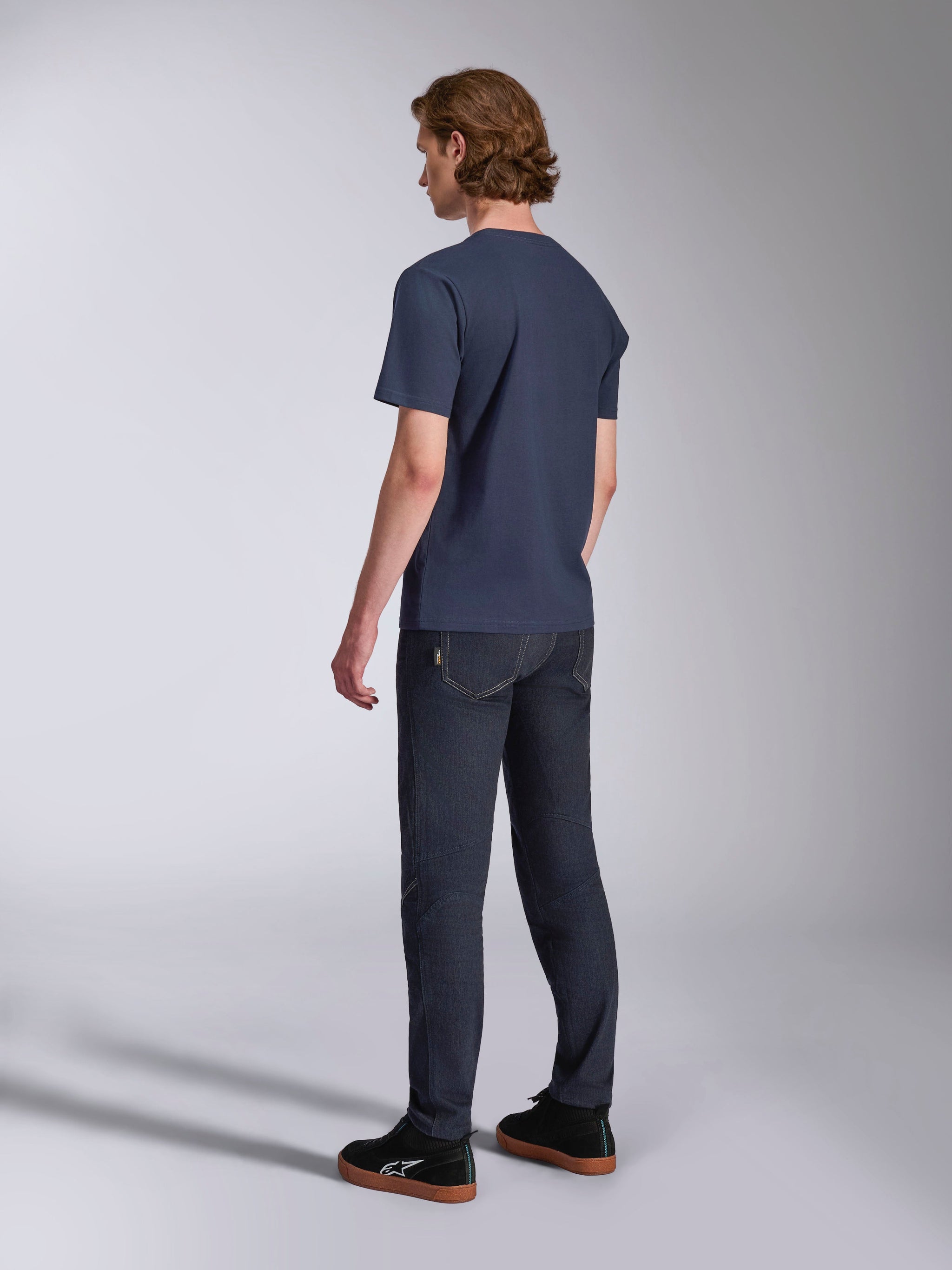 Alpinestars Ageless 2.0 CSF Tee, camiseta de manga corta, azul marino, vista trasera, combinada con pantalones vaqueros oscuros y zapatillas negras, estilo casual motorsport streetwear