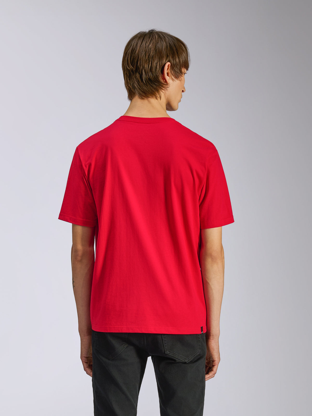 Camiseta Alpinestars Ageless Shadow CSF, camiseta de manga corta, roja, vista trasera en modelo, combinada con pantalones negros, estilo casual motorsport streetwear