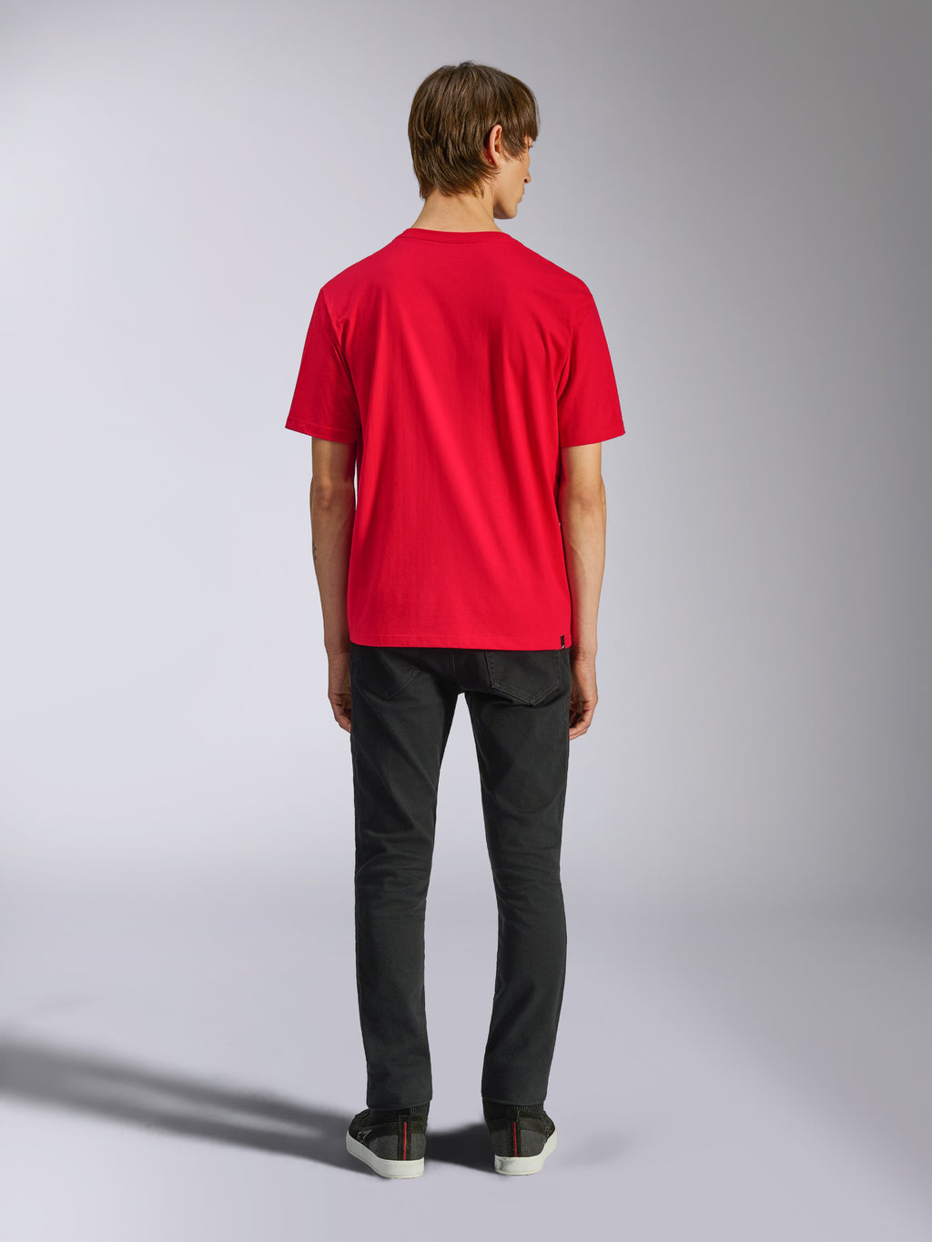 Alpinestars Ageless Shadow CSF Tee, camiseta de manga corta, roja, vista posterior en modelo con pantalones negros, estilo casual streetwear de automovilismo