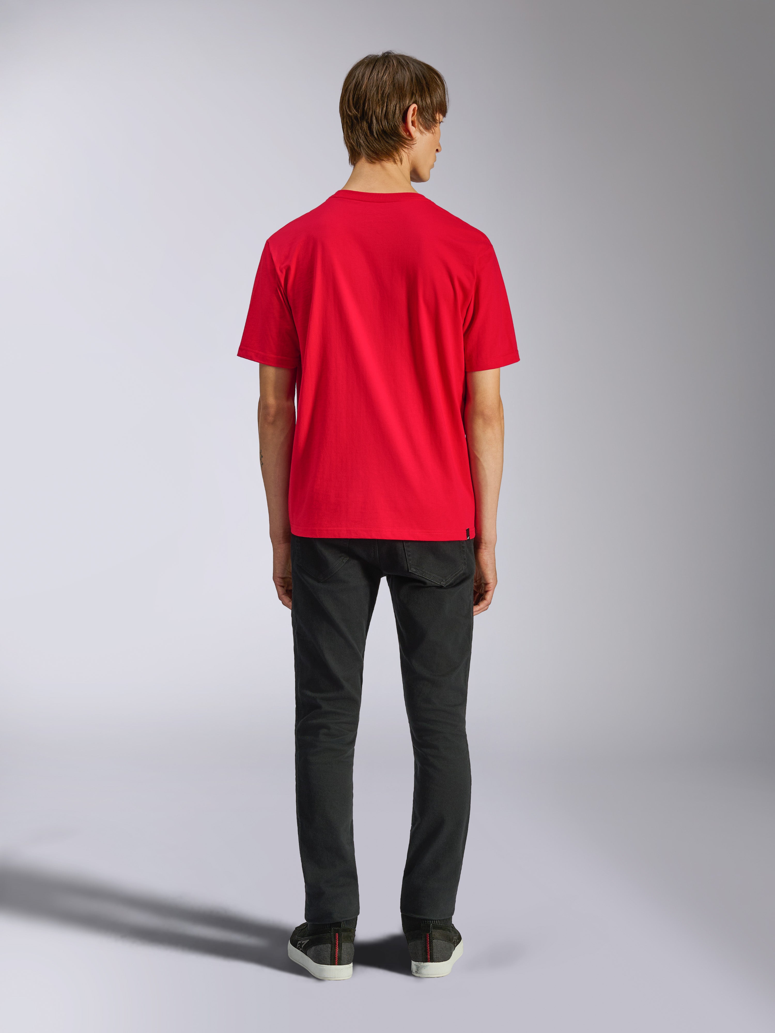 Alpinestars Ageless Shadow CSF Tee, camiseta de manga corta, roja, vista posterior en modelo con pantalones negros, estilo casual streetwear de automovilismo