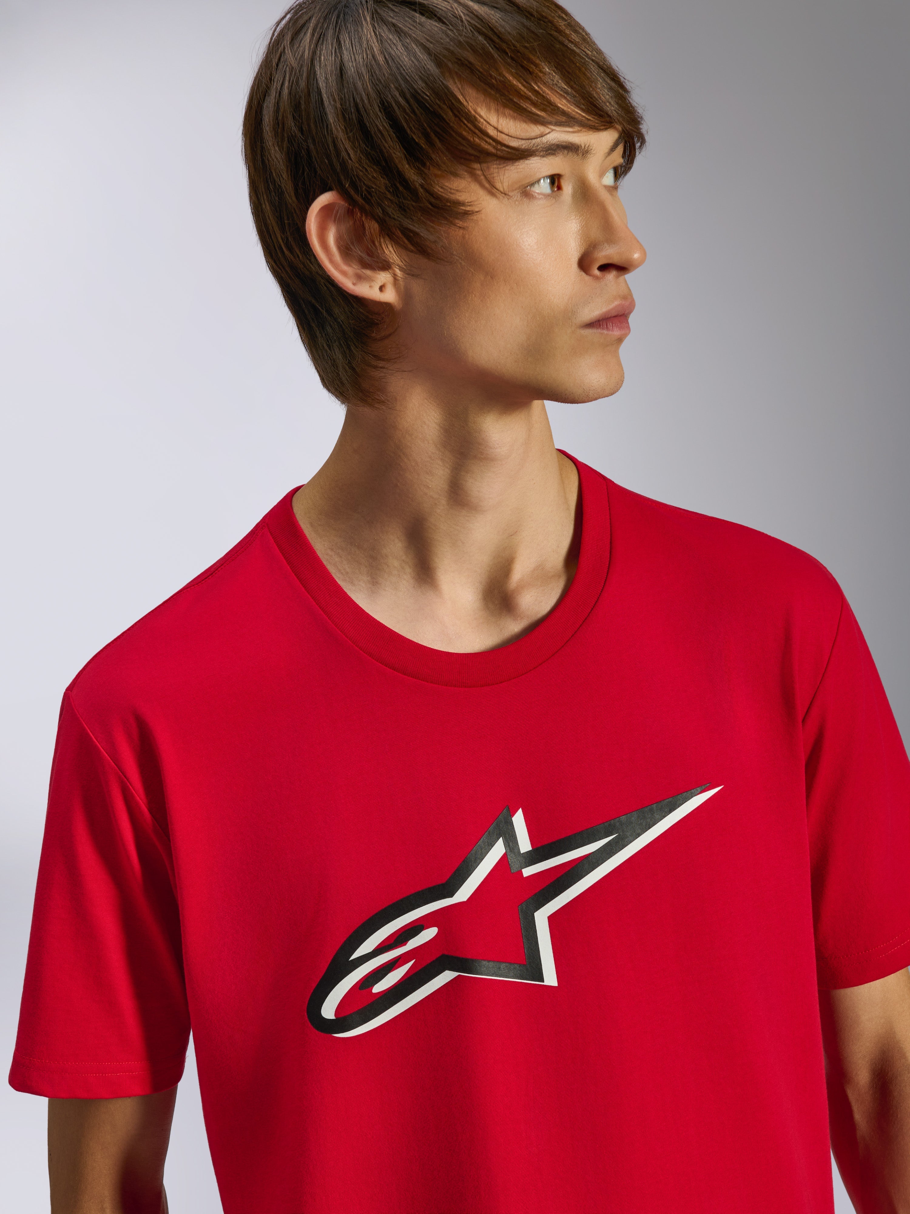 Alpinestars Ageless Shadow CSF Tee, camiseta de manga corta, roja, con el logotipo Ageless frontal con efecto de sombra en blanco y negro, usada por un modelo, ropa casual de estilo motorsport streetwear