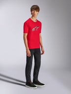 Alpinestars Ageless Shadow CSF Tee, camiseta de manga corta roja, con un gran logotipo Ageless en el pecho, usada por un modelo con pantalones negros y zapatillas, estilo streetwear casual de automovilismo