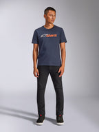 Camiseta Alpinestars Blaze 2.0 CSF, camiseta de manga corta, azul marino con el logotipo de Astars en blanco y naranja, combinada con pantalones negros y zapatillas negras, ropa urbana casual inspirada en el automovilismo