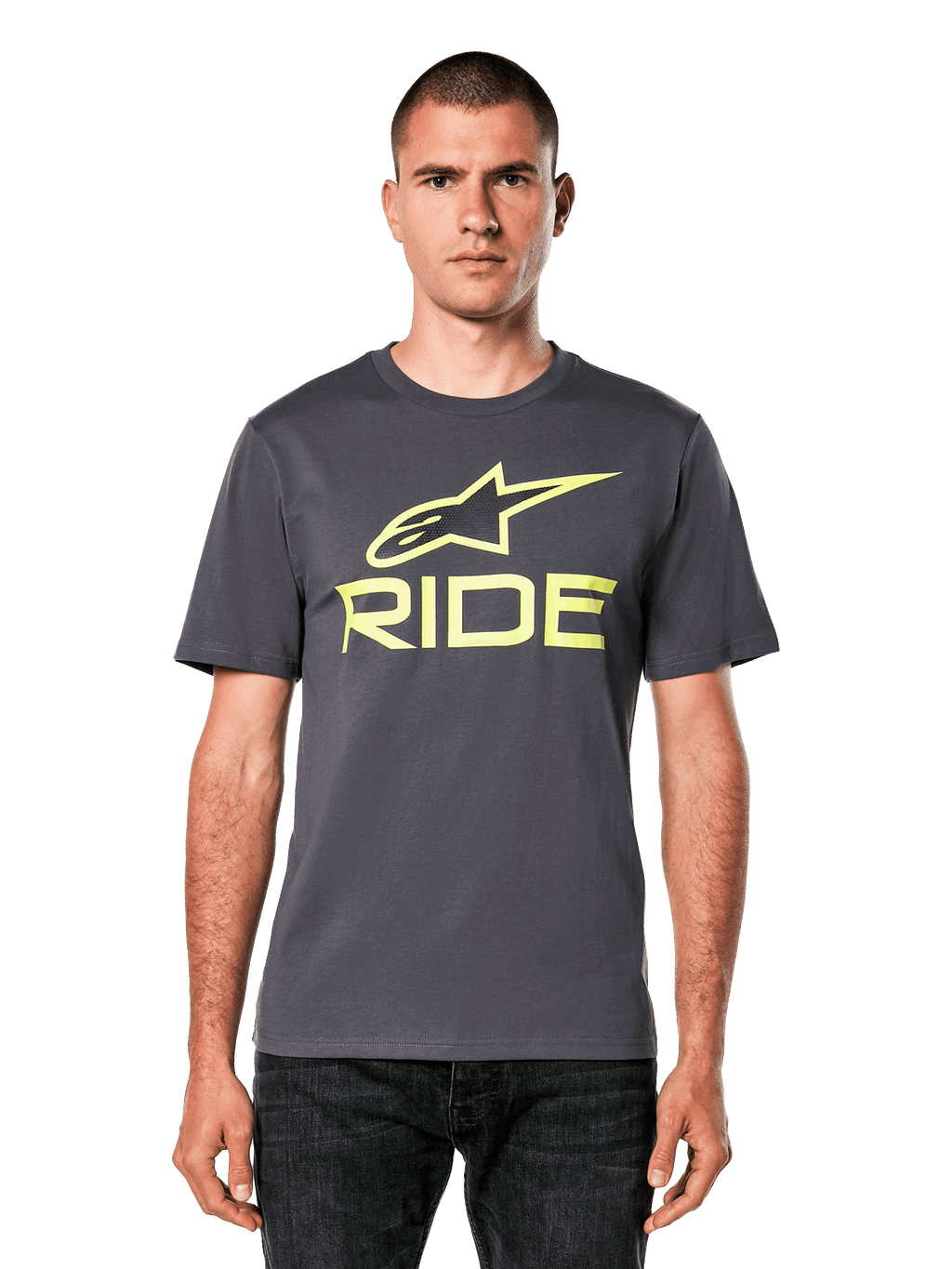 Alpinestars Ride 4.0 CSF Tee, camiseta de manga corta, gris carbón con logotipos Astars y Ride en amarillo lima, estilo streetwear casual de motociclismo, usada por un modelo con vaqueros oscuros sobre un fondo blanco