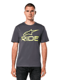 Alpinestars Ride 4.0 CSF Tee, camiseta de manga corta, gris carbón con logotipos Astars y Ride en amarillo lima, estilo streetwear casual de motociclismo, usada por un modelo con vaqueros oscuros sobre un fondo blanco
