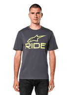 Alpinestars Ride 4.0 CSF Tee, camiseta de manga corta, gris carbón con logotipos Astars y Ride en amarillo lima, estilo streetwear casual de motociclismo, usada por un modelo con vaqueros oscuros sobre un fondo blanco
