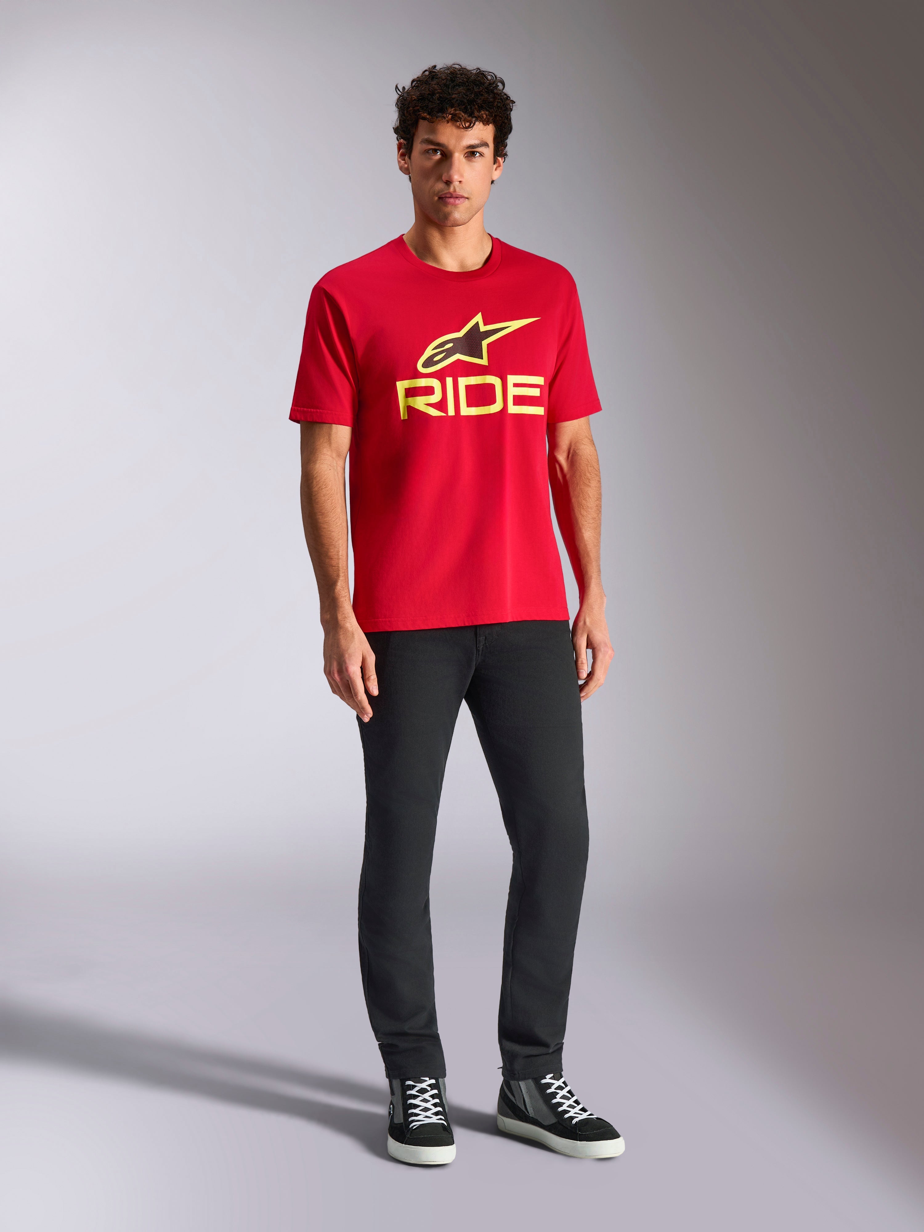 Alpinestars Ride 4.0 CSF Tee, Short Sleeve T-Shirt, Red with Hi-Vis Yellow Alpinestars Star and Ride Logo, worn by model with black pants and sneakers, Casual Motorsport Sportswear