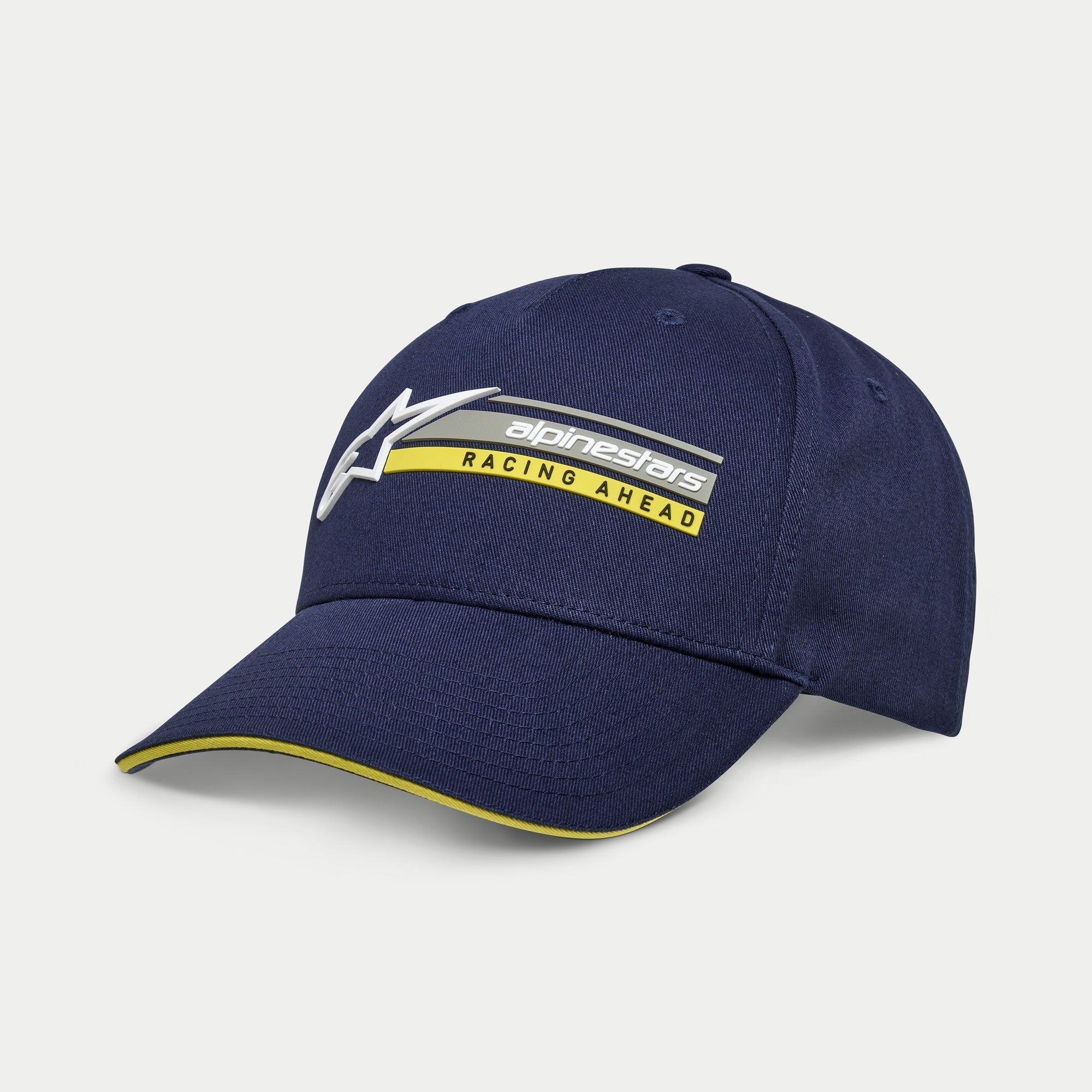 Alpinestars Par Hat, Navy Blue Snapback Cap, curved bill with yellow sandwich edge, 3D embroidered logo with 'Racing Ahead' graphic, casual motorsport-inspired headwear