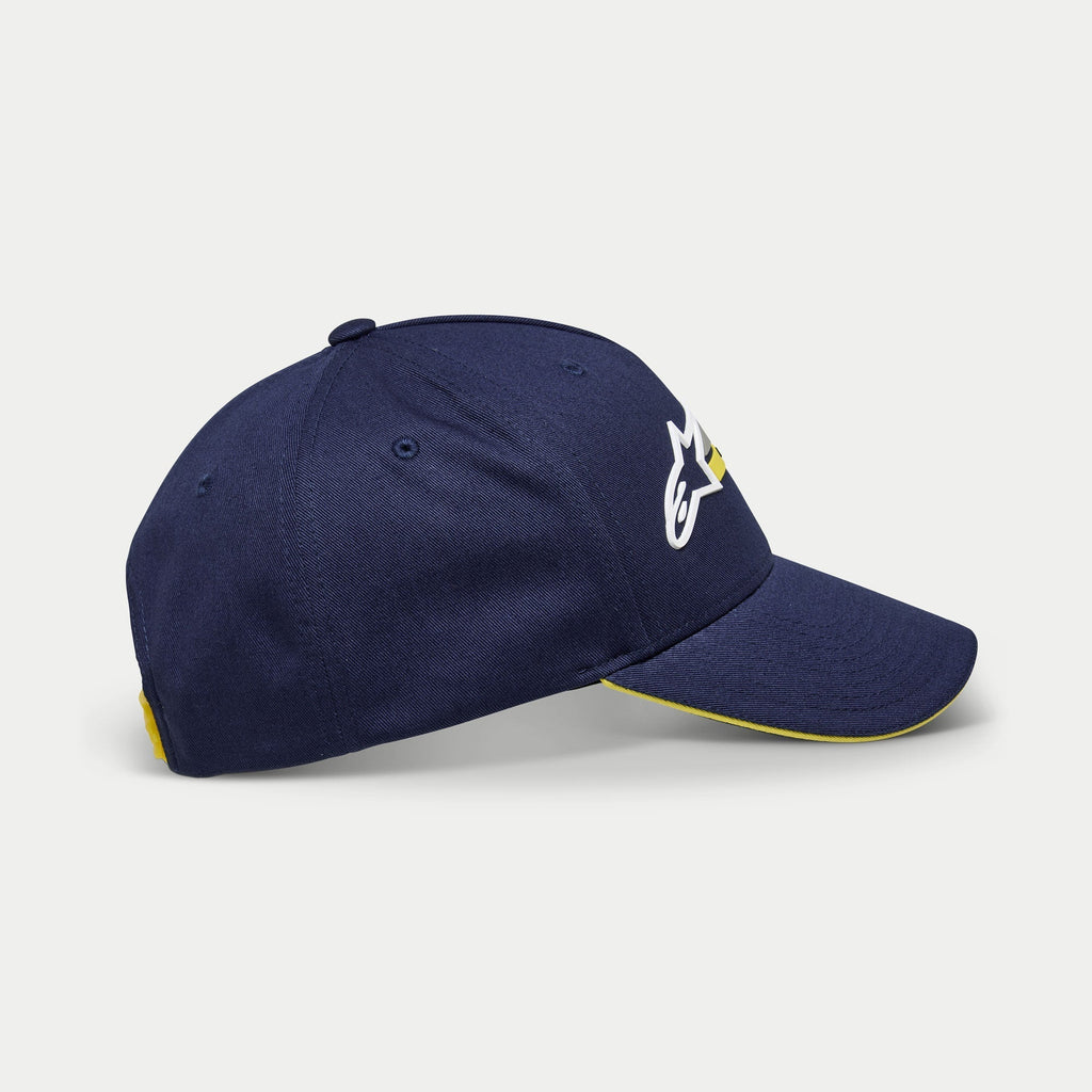 Alpinestars Par Hat, gorra de béisbol azul marino, vista lateral que muestra el bordado del logotipo en blanco y amarillo, visera curva con borde tipo sándwich amarillo, accesorio casual con corona estructurada