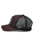 Gorra Trucker Heritage Patch de Alpinestars, marrón y negro, vista lateral que muestra la parte frontal de sarga marrón y la parte trasera de malla negra, parche lateral blanco con el logotipo Ageless, corona estructurada y visera curva