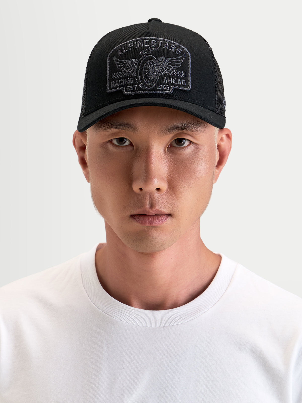 Alpinestars Gorra Heritage Patch, gorra trucker casual, negra y gris, con visera curva y parche bordado, vista frontal en modelo