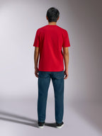 Alpinestars Ageless Shadow CSF Tee, back view of red short sleeve t-shirt, worn with dark blue denim jeans and black sneakers, casual motorsport streetwear