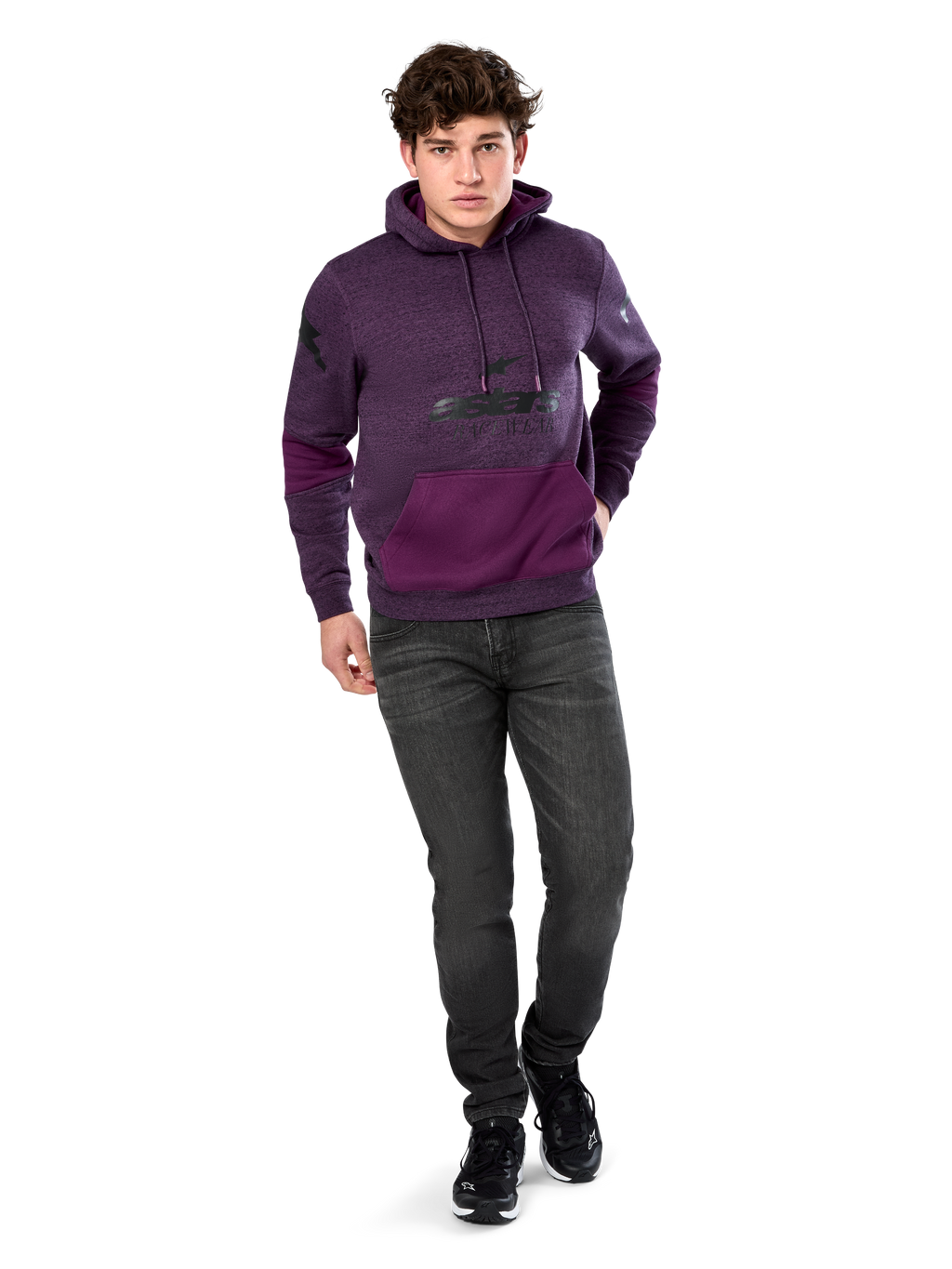 Sudadera Alpinestars Perpetuate Hoodie, ropa urbana casual, forro polar jaspeado púrpura con bloques de tela púrpura oscuro en el bolsillo canguro y mangas, logotipo negro en el pecho, capucha con cordón, lucida por modelo con vaqueros gris oscuro y zapatillas negras