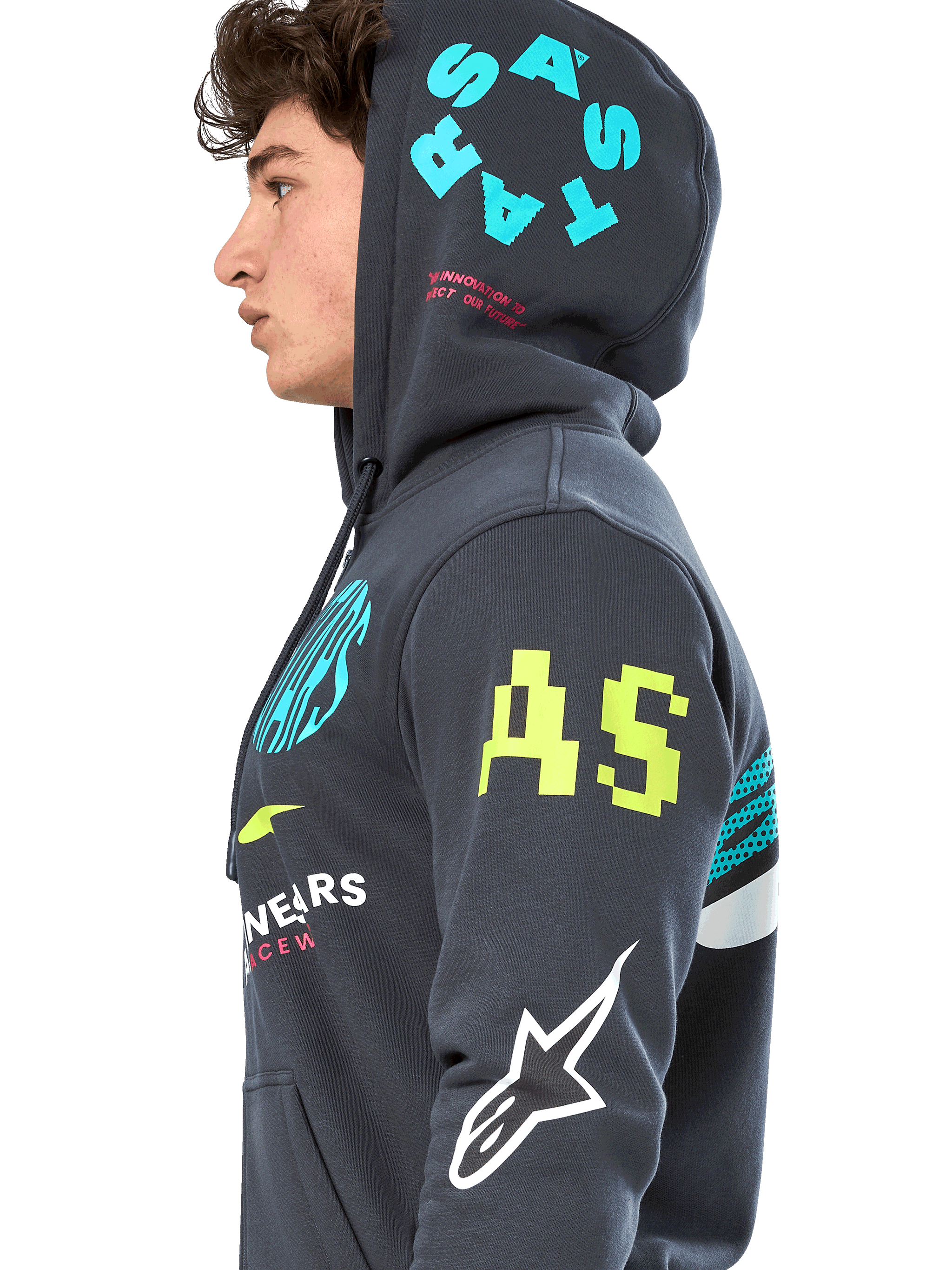 Alpinestars Variegate Hoodie, sudadera de forro polar gris plomo con cremallera frontal, perfil lateral del modelo, diseño con múltiples logotipos en amarillo neón, azul claro y blanco, incluye marca 'AS' en la manga y 'STARS' en la capucha, ropa urbana casual inspirada en el automovilismo