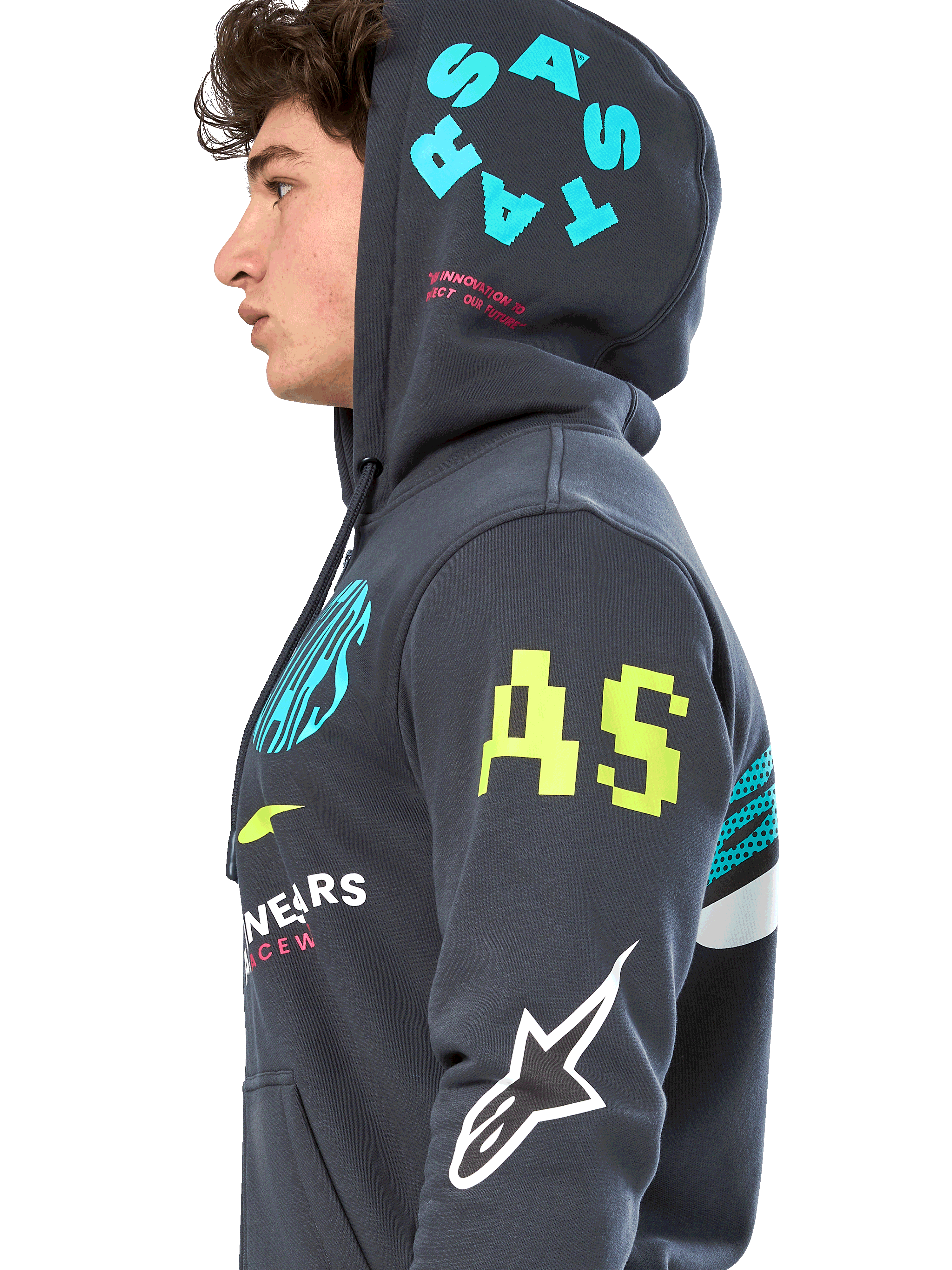 Alpinestars Variegate Hoodie, sudadera de forro polar gris plomo con cremallera frontal, perfil lateral del modelo, diseño con múltiples logotipos en amarillo neón, azul claro y blanco, incluye marca 'AS' en la manga y 'STARS' en la capucha, ropa urbana casual inspirada en el automovilismo