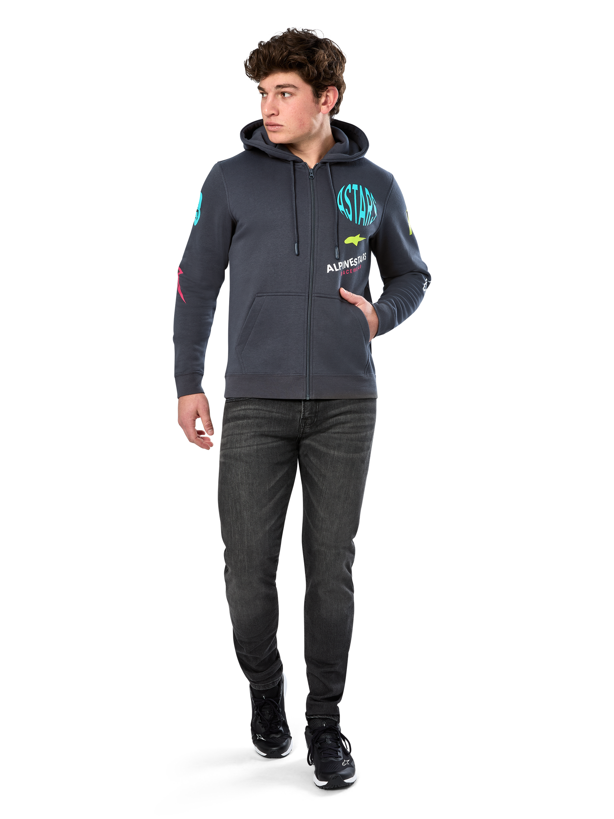 Alpinestars Variegate Hoodie, sudadera de forro polar con cremallera frontal, gris Gunmetal, usada por un modelo con vaqueros negros y zapatillas, con la marca 'ASTARS' en color turquesa y logotipos coloridos en las mangas y el pecho, ropa urbana casual de inspiración motorsport