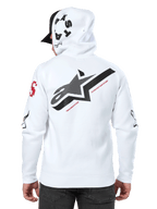 Sudadera con capucha Alpinestars Variegate, blanca, vista posterior con un gran logotipo de estrella negro con texto en rojo, arte de múltiples logotipos en las mangas y la capucha, estilo streetwear casual de motorsport