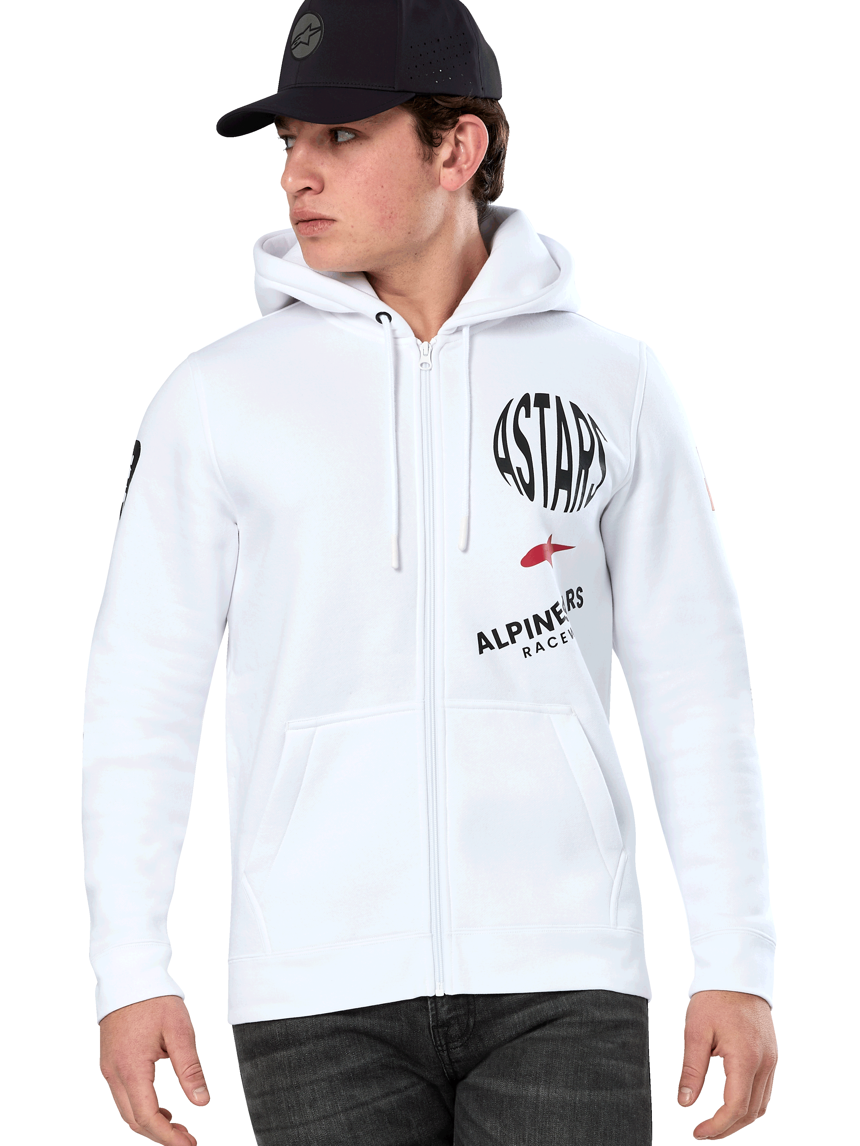 Alpinestars Variegate Hoodie, sudadera blanca con cremallera y capucha, gráficos de carreras ASTARS en negro y rojo, usada por un modelo con gorra negra y vaqueros oscuros, estilo urbano casual de automovilismo con bolsillo canguro y capucha con cordón