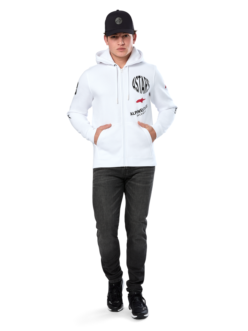 Alpinestars Variegate Hoodie, sudadera blanca de forro polar con cremallera, arte de múltiples logotipos con 'ASTARS' y logotipo de estrella roja en el pecho, detalles gráficos en las mangas, usada por un modelo con gorra negra y vaqueros negros, moda urbana casual de motorsport