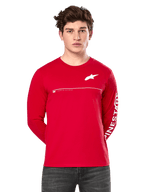 Alpinestars Committed CSF Long Sleeve Tee, roja, usada por un modelo, con logo de Astars blanco en el pecho, gráfico de Alpinestars en la manga y línea blanca horizontal, estilo urbano casual inspirado en el motor