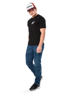 Alpinestars Formulate Csf Tee, Short Sleeve T-Shirt, Black with white Astars chest logo, worn by a model with blue jeans, a burgundy and white cap, and black sneakers, casual motorsport-inspired streetwear