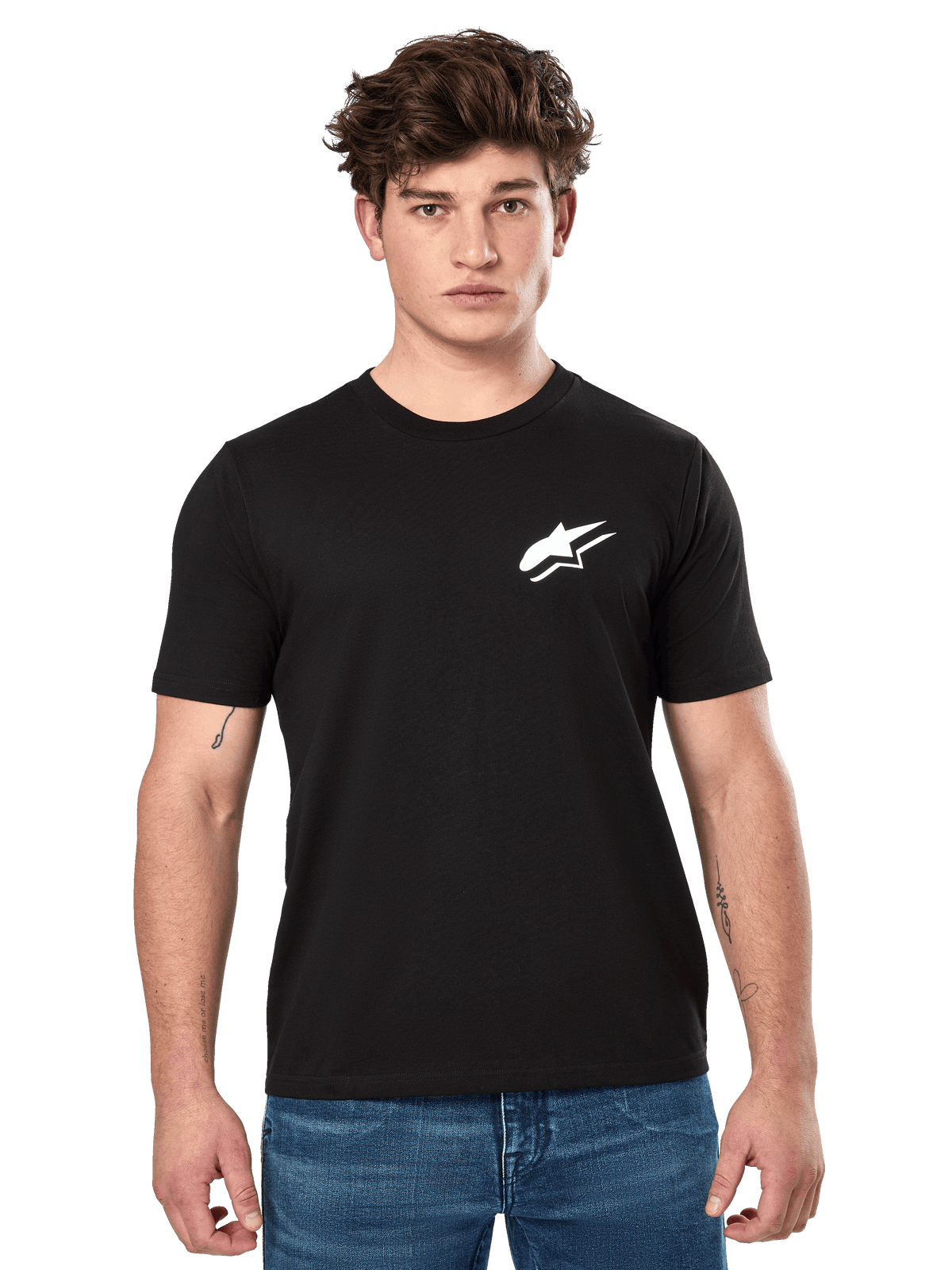 Alpinestars Formulate CSF Tee, camiseta de manga corta en color negro, lucida por un modelo masculino con vaqueros azules, con el logotipo blanco de Astars en el pecho, ropa de estilo de vida casual inspirada en el automovilismo