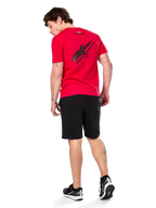 Camiseta Alpinestars Formulate CSF, camiseta de manga corta, roja, logotipo grande de Astars perforado en negro en la espalda, combinada con pantalones cortos negros y zapatillas, ropa urbana informal inspirada en el mundo del motor