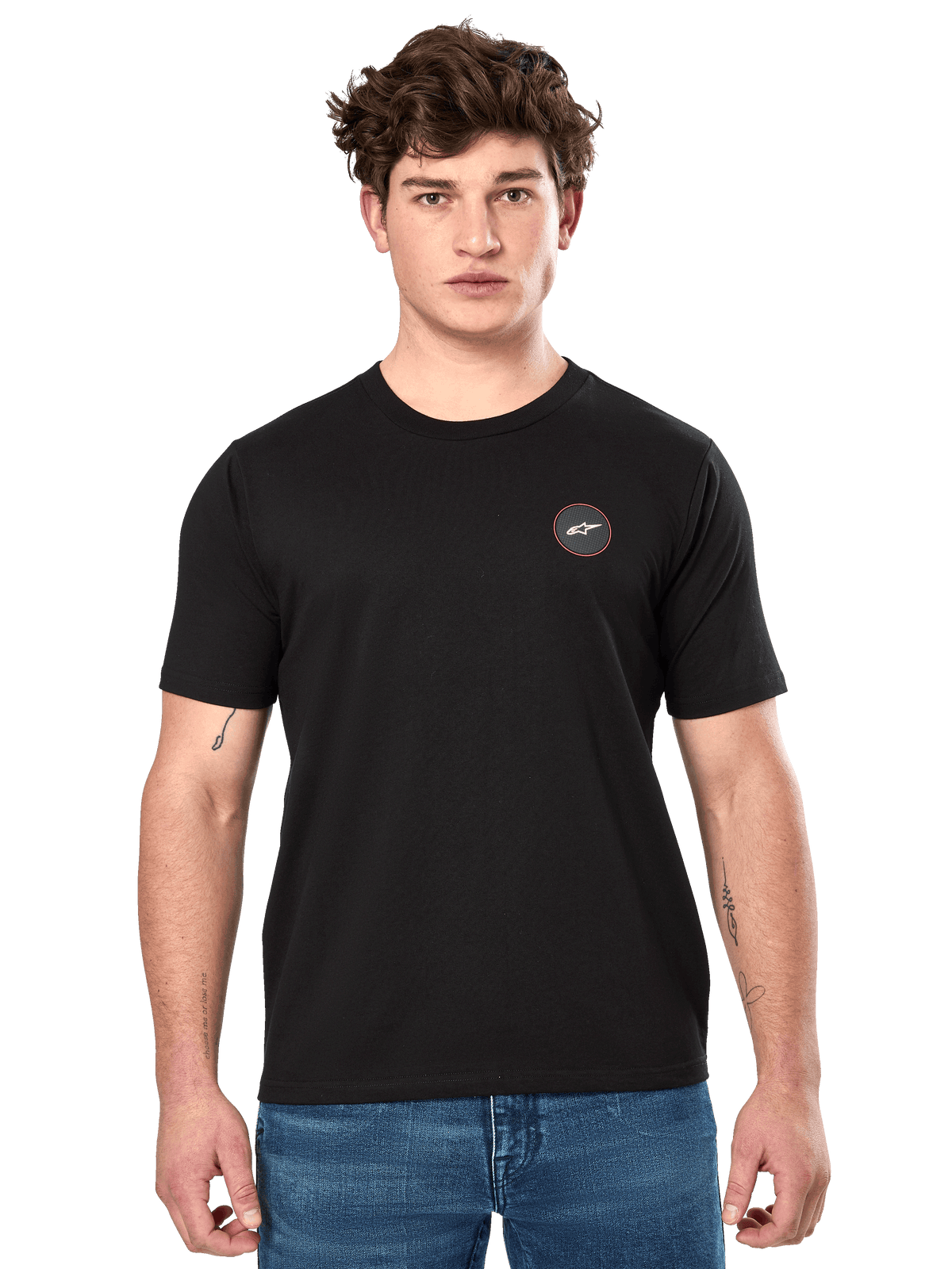 Alpinestars Dot Carbon CSF Tee, camiseta de manga corta negra, pequeño logotipo circular en el pecho con Astar blanco y borde rojo, usada por un modelo con vaqueros azules, ropa urbana casual de automovilismo