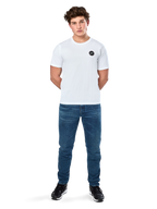 Alpinestars Dot Carbon Csf Tee, camiseta de manga corta, blanca, logotipo circular Astars con efecto de fibra de carbono, ropa casual de estilo automovilismo, usada por un modelo masculino con pantalones vaqueros azules y zapatillas negras
