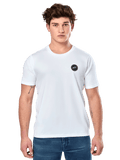 Alpinestars Dot Carbon CSF Tee, camiseta de manga corta blanca, modelo masculino vistiendo camiseta blanca con pequeño logo circular negro en el pecho y vaqueros azules, estilo casual motorsport