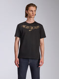 Camiseta Alpinestars Luxo CSF, camiseta de manga corta, negra, logotipo de Astars perfilado en dorado en el pecho, combinada con vaqueros azul oscuro, ropa urbana casual de estilo motorista
