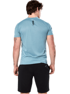 Alpinestars Point Performance Tee, camiseta de manga corta, Ice Blue, vista trasera en modelo que muestra el estampado vertical negro de la palabra astars, combinada con pantalones cortos negros, ropa deportiva casual de alto rendimiento