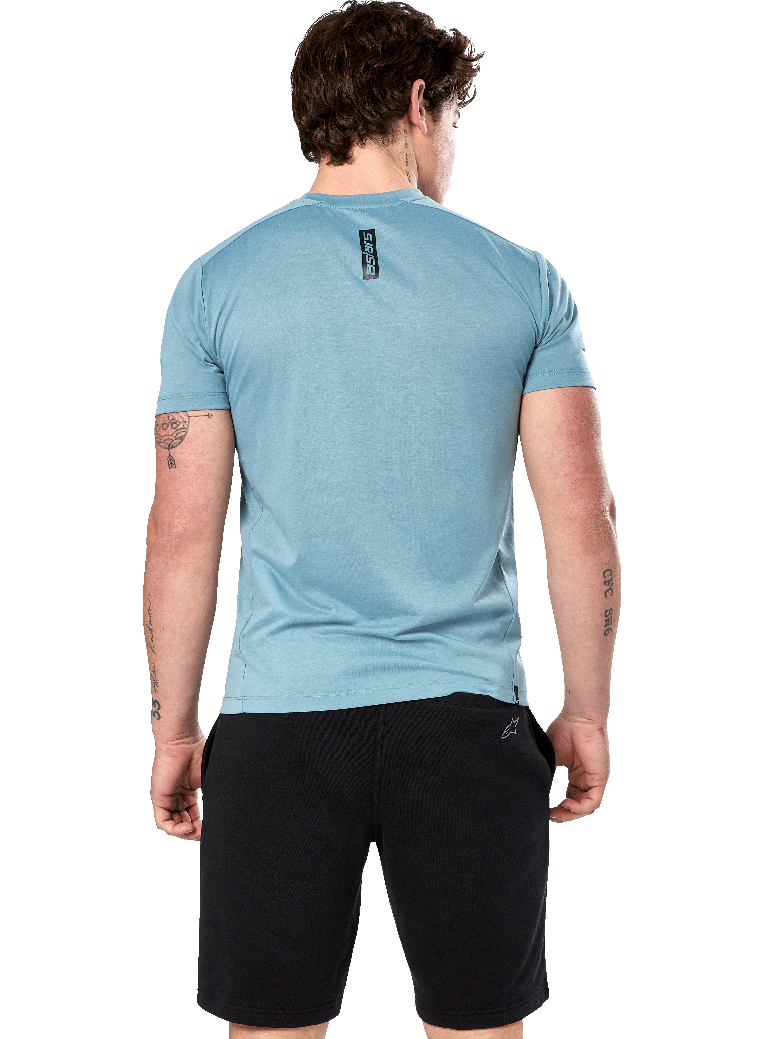 Alpinestars Point Performance Tee, camiseta de manga corta, Ice Blue, vista trasera en modelo que muestra el estampado vertical negro de la palabra astars, combinada con pantalones cortos negros, ropa deportiva casual de alto rendimiento