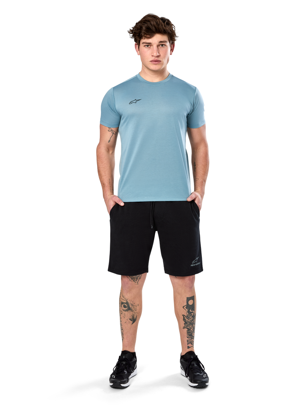 Camiseta Alpinestars Point Performance, camiseta de manga corta, azul hielo, con un pequeño logotipo frontal negro, cuello redondo, usada por un modelo con pantalones cortos y zapatillas negras, ropa deportiva casual con absorción de humedad