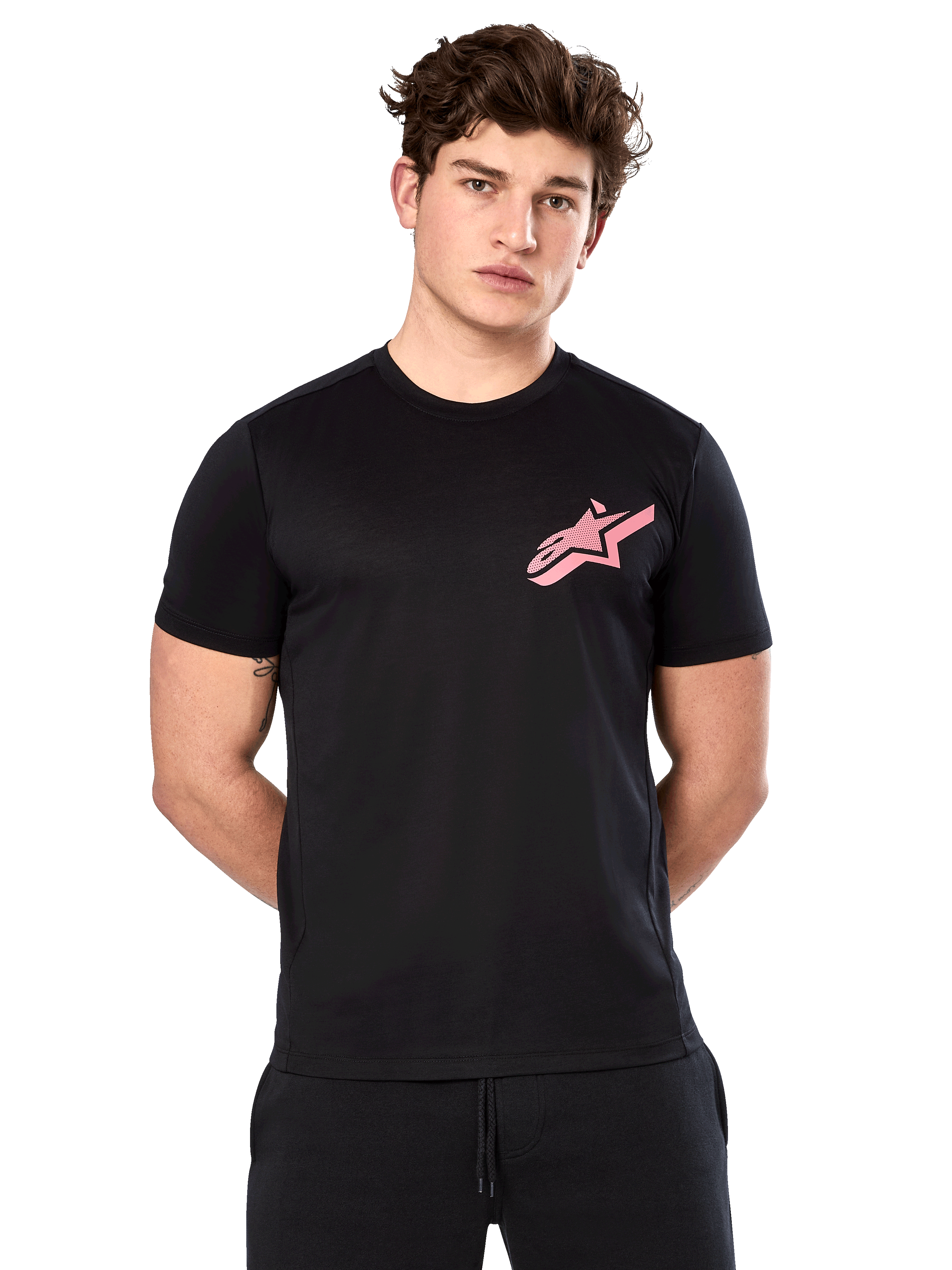 Alpinestars Attrition Performance Tee, camiseta de manga corta para hombre, negra con logo Astars rosa en el pecho, vestida por un modelo masculino, ropa de rendimiento casual para deportes de motor