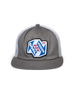 Gorra Trucker Alpinestars That Way, gris y blanca, corona estructurada con visera plana y parte trasera de malla blanca, con un parche frontal grande con el gráfico 'One Goal One Vision', estilo casual streetwear de automovilismo