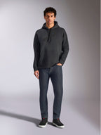 Alpinestars Emergent Oversized Hoodie, casual lifestyle streetwear, black with tonal 3D embroidered logo, drawstring hood, kangaroo pocket, oversized fit, worn by a model with dark blue jeans and black sneakers.