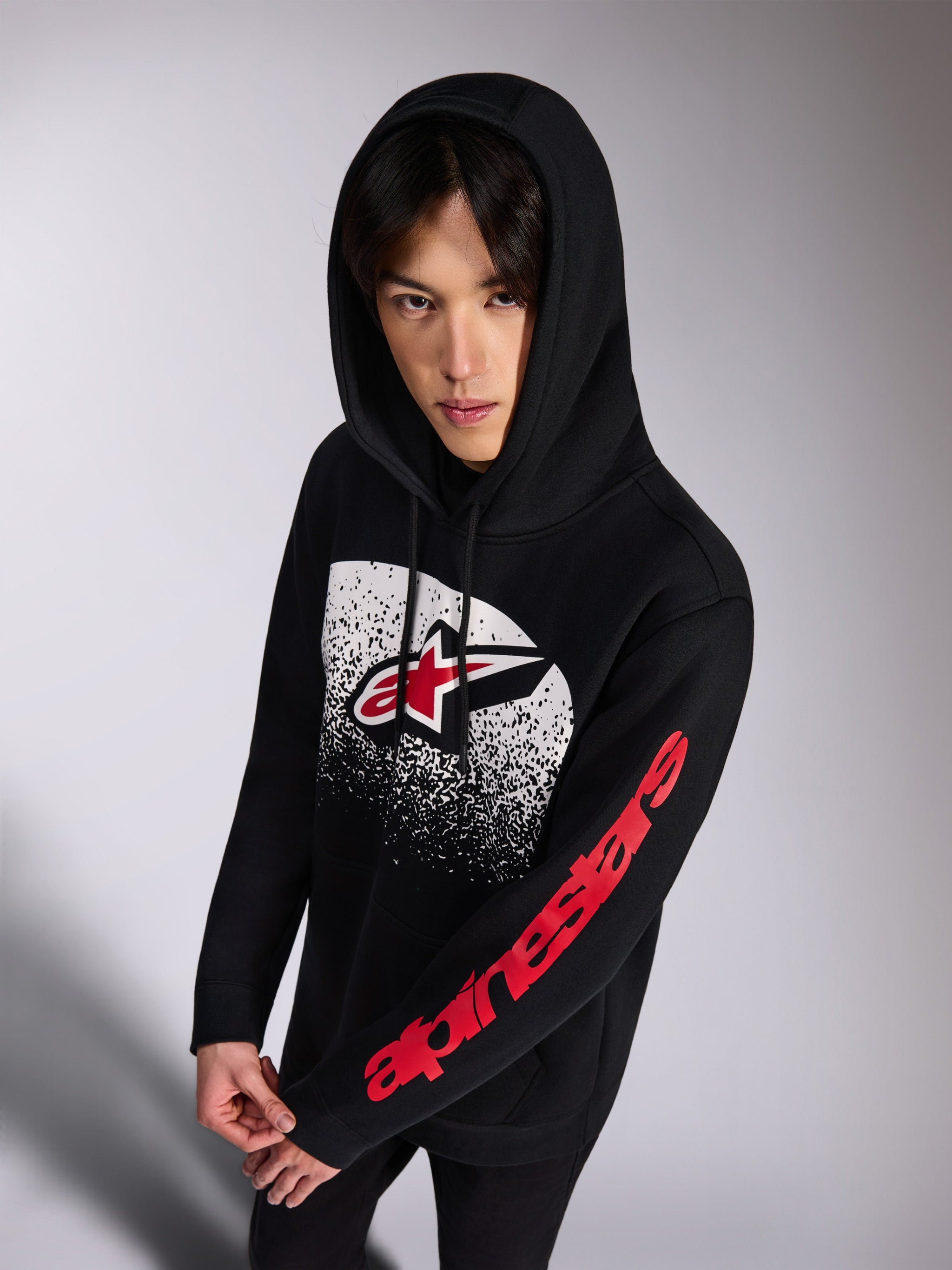 Alpinestars Obsessed Hoodie, black pullover fleece hoodie, front red and white Astars logo with white distressed MX gradation, red Alpinestars wordmark on the sleeve, drawstring hood, casual motorsport-inspired streetwear