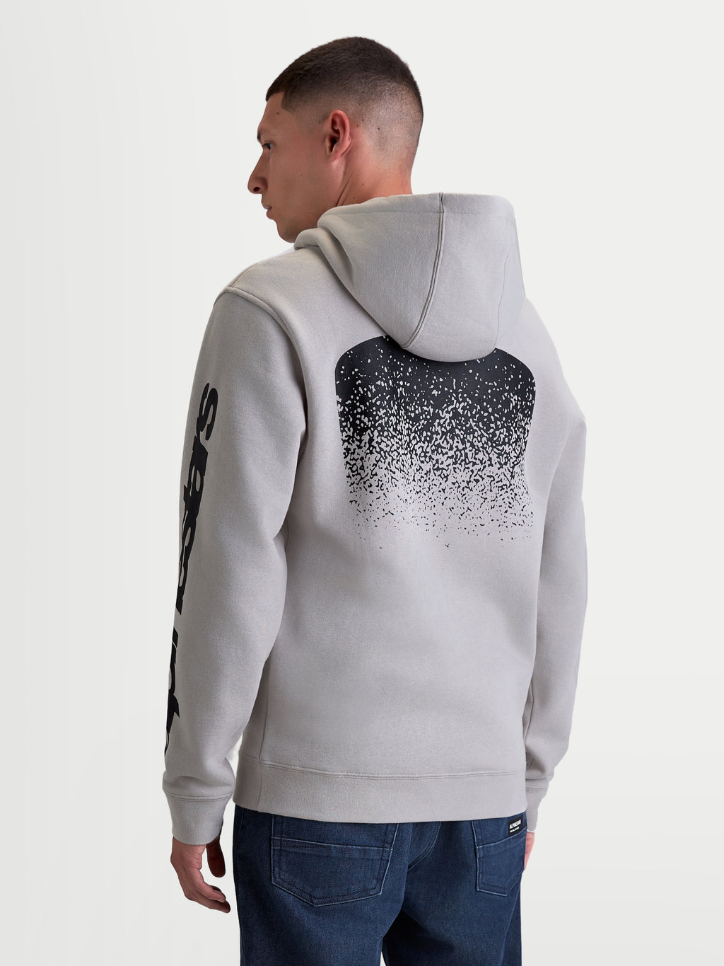Alpinestars sudadera con capucha Obsessed, sudadera de forro polar para hombre en color gris, con un gran gráfico negro degradado inspirado en MX en la espalda y marca en la manga, vista trasera en modelo, ropa de estilo casual para motorsport