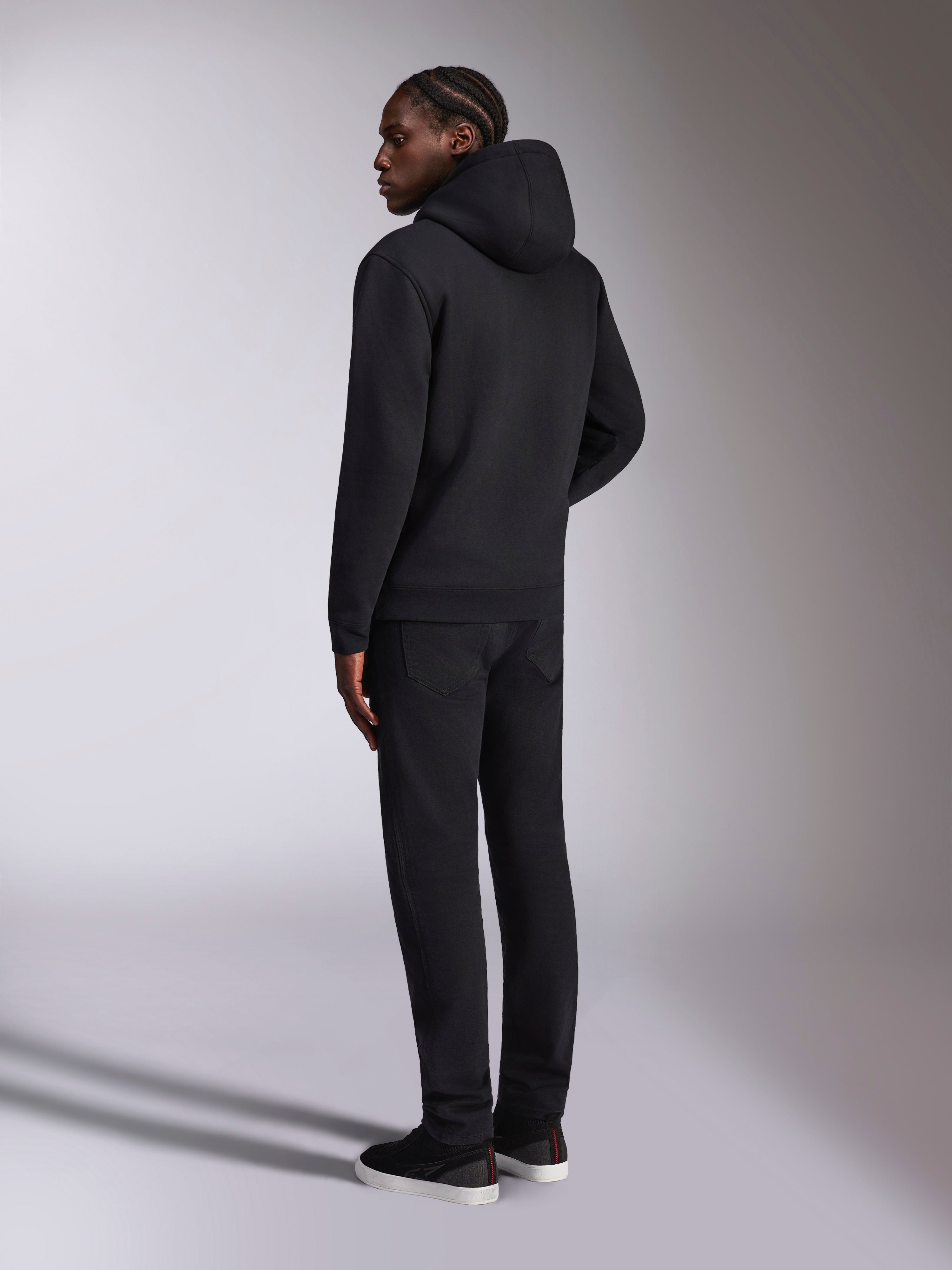 Alpinestars Pulse Hoodie, ropa urbana casual, negro, vista trasera de un modelo con sudadera con capucha de forro polar negra sólida, diseño minimalista con puños y dobladillo de canalé