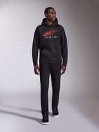 Alpinestars Pulse Hoodie, sudadera urbana casual negra, logotipo Astars Combo en rojo y gris con líneas de velocidad desvanecidas en el pecho, capucha con cordón, bolsillo tipo canguro, manga larga, combinada con pantalones negros y zapatillas, diseño inspirado en el automovilismo