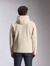 Sudadera con capucha Alpinestars Pulse, color arena, vista trasera de modelo masculino vistiendo la sudadera lisa, combinada con vaqueros de denim oscuro, ropa urbana casual inspirada en el automovilismo