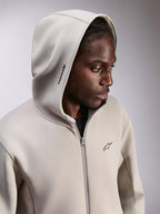 Alpinestars Cypher Hoodie, sudadera de forro polar con cremallera, Gris Cemento, con la capucha puesta, con el logotipo Alpinestars en la capucha y un pequeño logo Astars en el pecho, ropa urbana casual inspirada en el motor