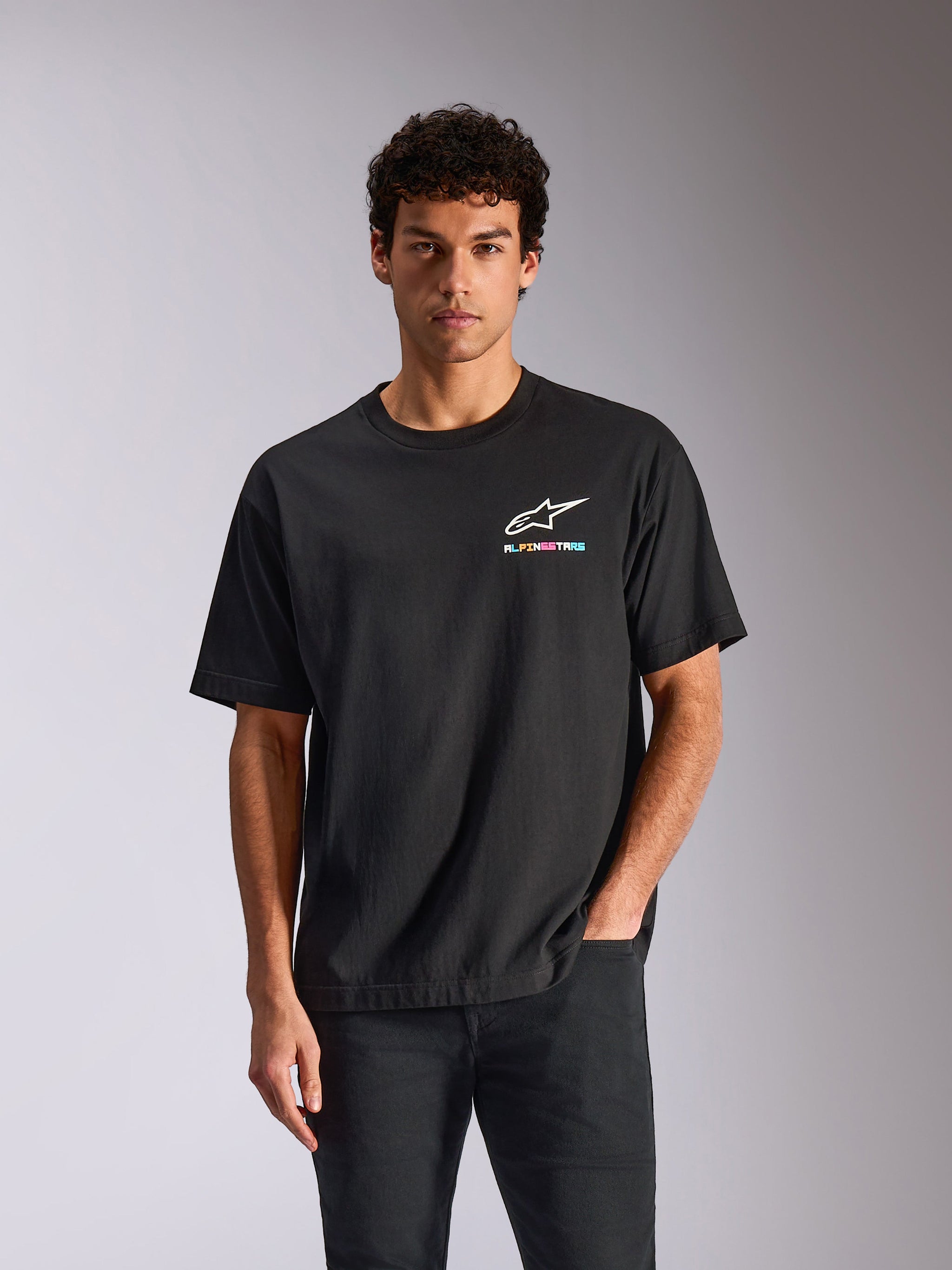 Alpinestars Wild Oversized CSF Tee, camiseta de manga corta, negra, logotipo Astars blanco con texto multicolor vibrante, ropa urbana casual de automovilismo
