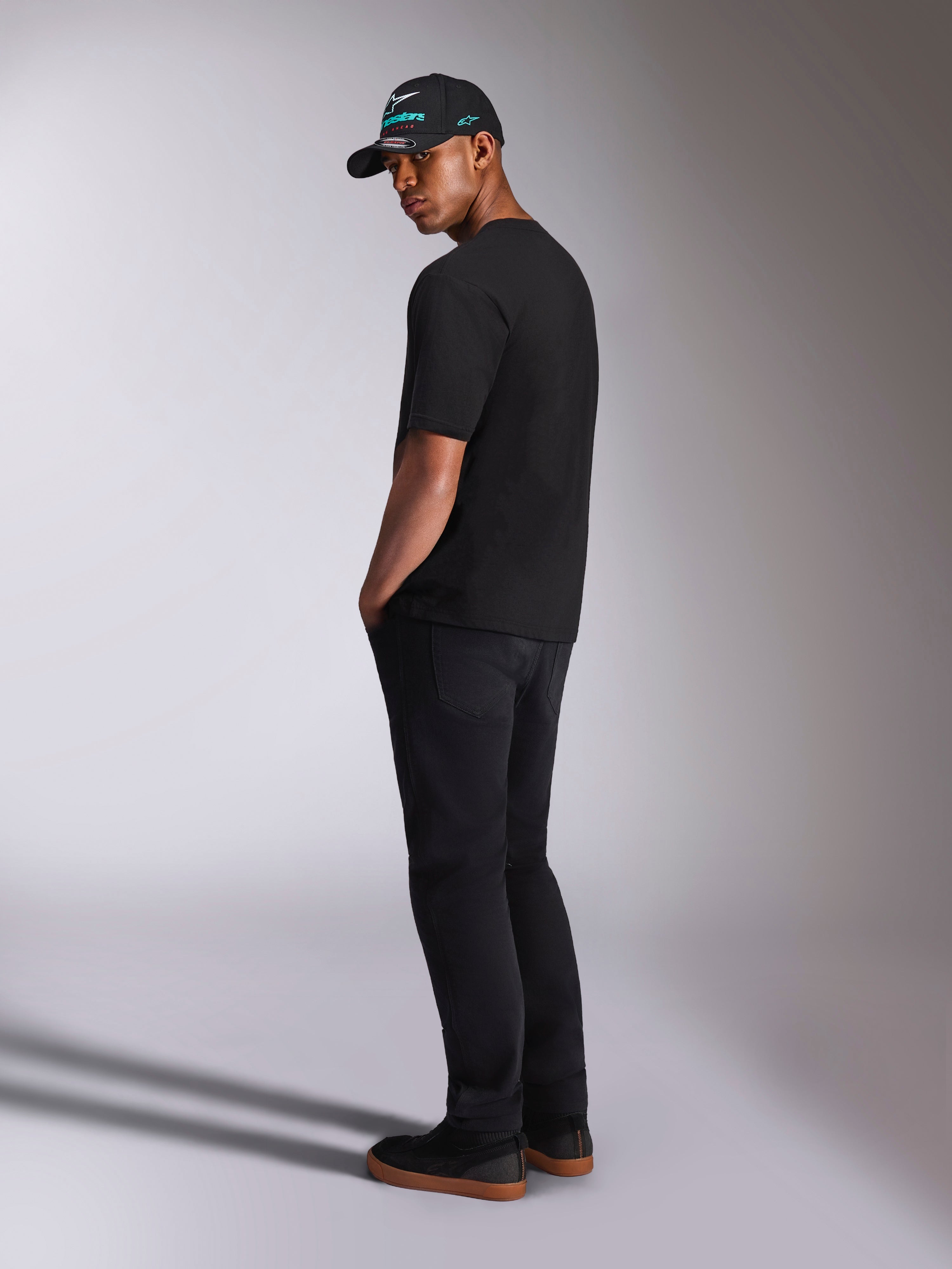 Alpinestars Ellipsoid CSF Tee, Short Sleeve T-Shirt, Black, back view on model wearing black pants and a black Alpinestars cap, casual motorsport lifestyle outfit